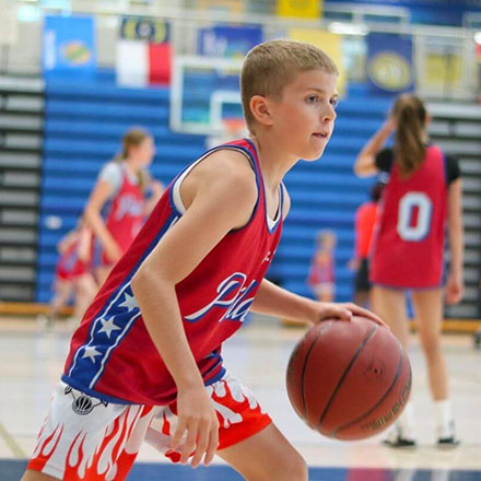 Boy camper dribbling up court