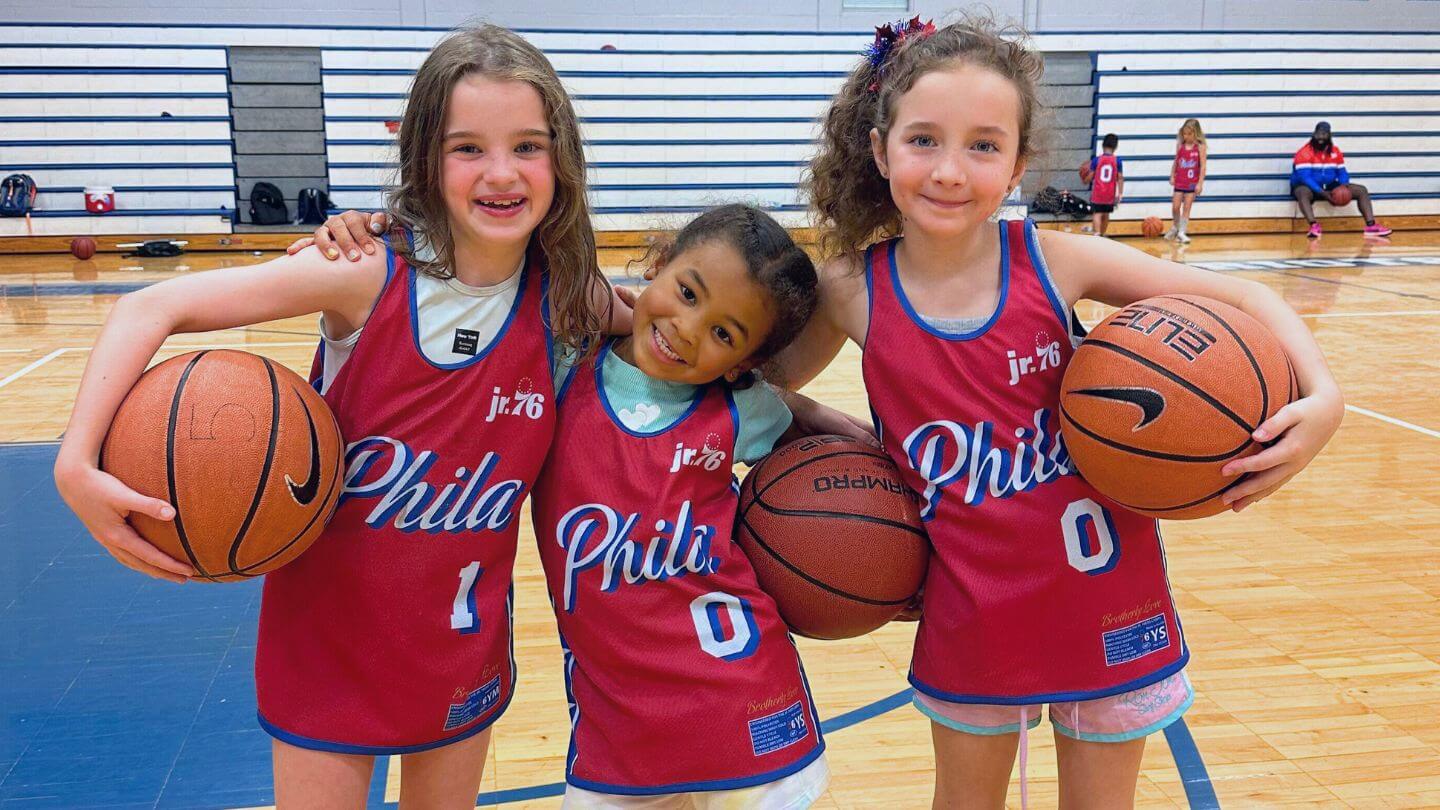 Three young girls campers holding basketballs